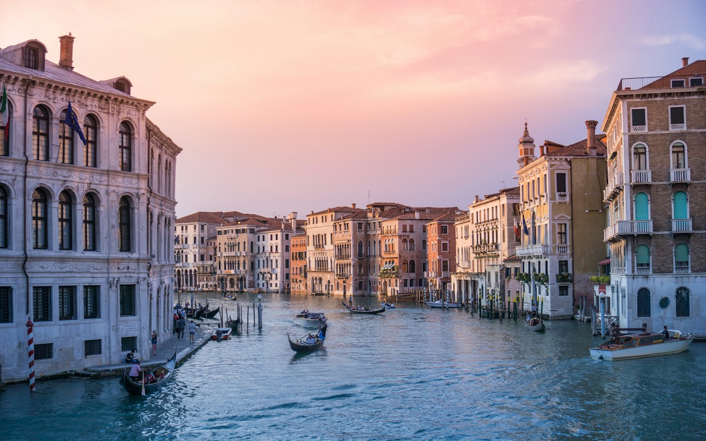 Gondolas on the Grand Canal in Venice under a warm orange sky